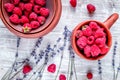 Raspberry in pottery cup with lavender on wooden background top view