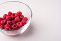 Raspberry red berries in transparent glass bowl plate tasty sweet bright on white background copy space macro Royalty Free Stock Photo