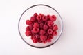 Raspberry red berries in transparent glass bowl plate tasty sweet bright on white background copy space macro Royalty Free Stock Photo