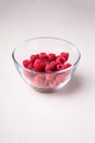 Raspberry red berries in transparent glass bowl plate tasty sweet bright on white background copy space macro Royalty Free Stock Photo