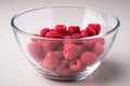 Raspberry red berries in transparent glass bowl plate tasty sweet bright on white background copy space macro Royalty Free Stock Photo