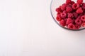 Raspberry red berries in transparent glass bowl plate tasty sweet bright on white background copy space macro Royalty Free Stock Photo