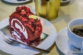 Raspberry roll cake and a cup of black coffee on a table in a cafe Royalty Free Stock Photo