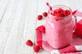 Raspberry smoothie in a mason jar against white wood, side orientation Royalty Free Stock Photo