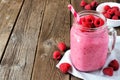 Raspberry smoothie in a mason jar against wood, side orientation Royalty Free Stock Photo