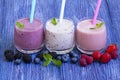 Raspberry, strawberry, blackberries, blueberry smoothie on blue wooden background. milkshake with fresh berries. healthy Royalty Free Stock Photo