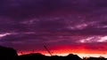 Raspberry sunset,landscape on the background of a cargo crane,sunset on a background of mountains. Royalty Free Stock Photo