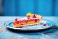 raspberry tart slice with oozing filling on a blue plate