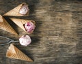 Raspberry vanilla ice cream scoop in a spoon with waffles cones