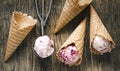 Raspberry vanilla ice cream scoop in a spoon with waffles cones