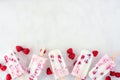 Raspberry yogurt ice pops, top down view bottom border on a white marble background