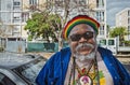 A rastafarian creole man is smiling in camera