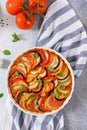 Ratatouille casserole on blue-white napkin background. Colorful layers of fresh summer vegetables: zucchini, eggplant, tomatoes Royalty Free Stock Photo