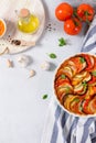 Ratatouille casserole on white background. Colorful layers of fresh summer vegetables: zucchini, eggplant, tomatoes and potatoes. Royalty Free Stock Photo