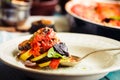 Ratatouille - a classic vegetarian dish from French cuisine. Baked vegetables in tomato sauce with basil and paprika. Blue wooden Royalty Free Stock Photo
