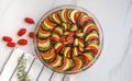 Ratatouille: Colorful layers of fresh summer vegetables: zucchini, eggplant, tomatoes on tomato sauce season with garlic and  fres Royalty Free Stock Photo