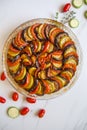 Ratatouille: Colorful layers of fresh summer vegetables: zucchini, eggplant, tomatoes on tomato sauce season with garlic and  fres Royalty Free Stock Photo