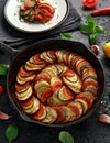 Ratatouille Vegetable Stew with zucchini, eggplants, tomatoes, garlic, onion and basil. on cast iron pan. Traditional