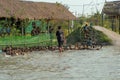 Ratchaburi, Thailand : January 20,2019 - Children enjoy run in the pond with mud for chasing the group of ducks in the farm