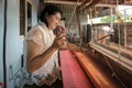 Local Thai weaver crafting traditional silk on a loom