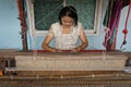 Local Thai weaver crafting traditional silk on a loom