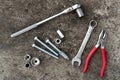 Ratched wrench, plier, bolts and wrenches on concrete background. Equipment. Engineering