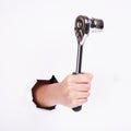 Ratchet wrench in a hand of the girl. Symbol of hard work, feminism and labor day. Isolate on white background