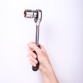 Ratchet wrench in a hand of the girl. Symbol of hard work, feminism and labor day. Isolate on white background Royalty Free Stock Photo