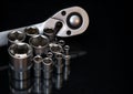 Ratchet wrench. Set of stainless steel hex sockets on shiny black surface. Universal professional tool for car repair. Low key Royalty Free Stock Photo