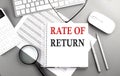 RATE OF RETURN text on notepad on chart with keyboard and calculator on grey background Royalty Free Stock Photo