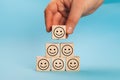 Rating customer experience. Hand putting wooden cube block shape with icon face smiley, The best excellent business Royalty Free Stock Photo