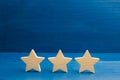 The rating of the hotel, restaurant, mobile application. Three stars on a blue background. The concept of rating and evaluation. Q Royalty Free Stock Photo