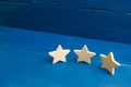 The rating of the hotel, restaurant, mobile application. Three stars on a blue background. The concept of rating and evaluation. Royalty Free Stock Photo
