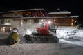 Ratrack snow grooming machine preparing slopes for skiers on ski resort in mountains on night Royalty Free Stock Photo