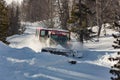 Ratrak rides among the trees pushing snow on a forest road