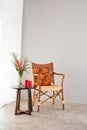 Rattan chair with orange colored pillow