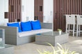 Rattan couch. Comfortable corner with focus on the blue pillows. Rattan sofa and table set