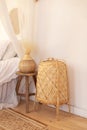 Rattan floor lamp and wooden coffee table with vase with pampas grass in bedroom interior. Large wicker lamp is on floor. Cozy dec Royalty Free Stock Photo
