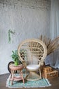 Rattan peacock chair in loft room with boho decorations