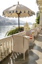 Rattan table and chairs under an umbrella in a street cafe on the shore near the lake in Udaipur, Rajasthan, India Royalty Free Stock Photo