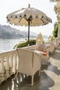 Rattan table and chairs under an umbrella in a street cafe on the shore near the lake in Udaipur, Rajasthan, India Royalty Free Stock Photo