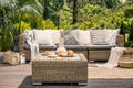 Rattan table and pillows on couch standing on a patio in the gar
