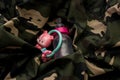 Rattle toy and baby bottle on military uniform. Love and war concept Royalty Free Stock Photo