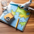 ravel Mockup with Compass, Glass of Water, Note Pad, Pen, Toy Airplane, and Touristic Map on Wooden Table Royalty Free Stock Photo