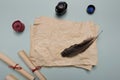 Raven feather, inkwell and old yellowed paper on red background. Copy space Royalty Free Stock Photo