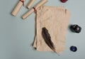 Raven feather, inkwell and old yellowed paper on red background. Copy space Royalty Free Stock Photo