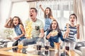 Raving fans cheering sports, as family of five watch football, or ice-hockey match on the TV at home, screaming from joy