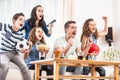 Raving fans cheering sports, as family of five watch football, match on the TV at home, screaming from joy