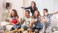 Raving fans cheering sports, as family of five watch football, match on the TV at home, screaming from joy