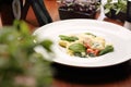 Ravioli pasta in white cream sauce with green leaves ,tomatoes and grated cheese, on a white plate, selective focus. Royalty Free Stock Photo